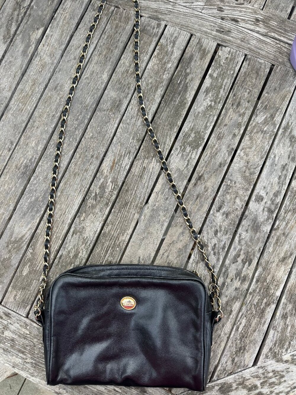 Genuine black leather Monet handbag with gold tone hardware, camera bag style
